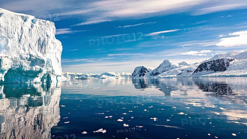 Tranquil Arctic landscape with icebergs and mountains under a blue sky, icebergs in the Southern Ocean in Antarctica