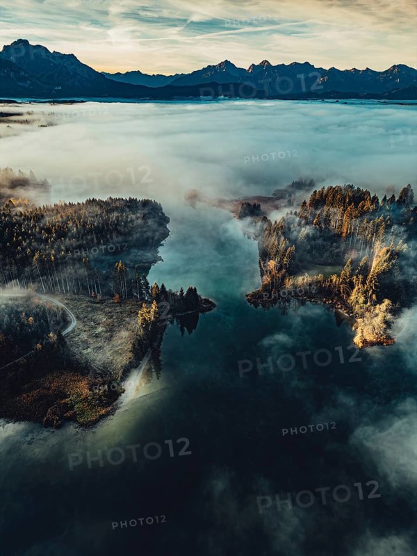 Autumn sunrise in the foothills of the Alps with fog at Illasbergsee and Forggensee near Halblech in Allgäu, Bavaria, Germany