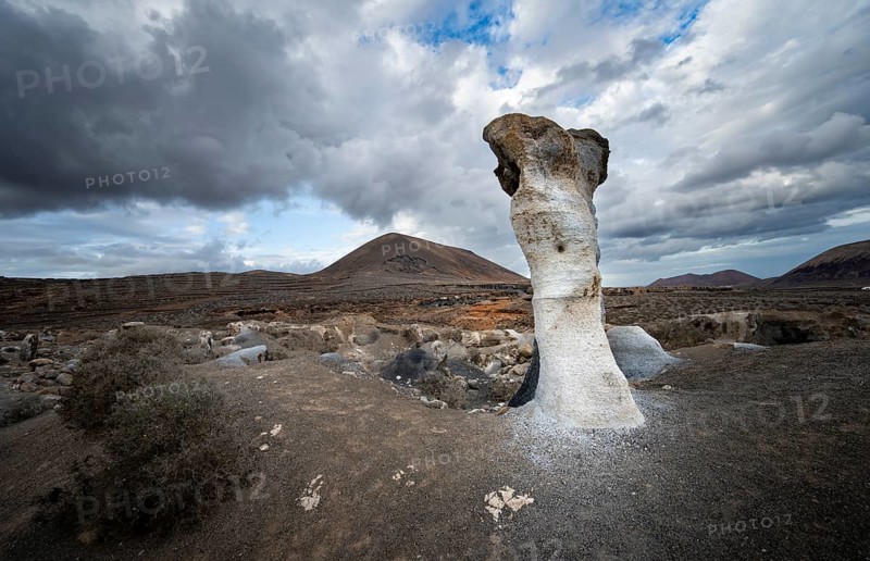 Eroded rock formations, volcanic landscape with dramatic cloudy skies, Ciudad Estratificada or Los Roferos, Antigua Rofera de Teseguite, Lanzarote, Canary Islands, Spain