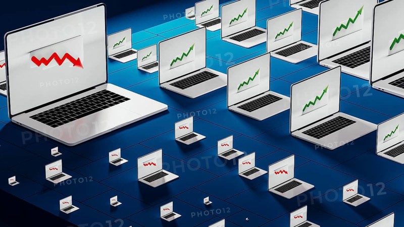 Laptops in a modern office show fluctuating stock trends, reflecting the dynamic nature of financial activities