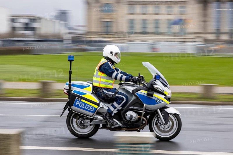 Reichstag Berlin with waving flags. Police motorcycle. Contributor. smudge effect. Berlin, Germany