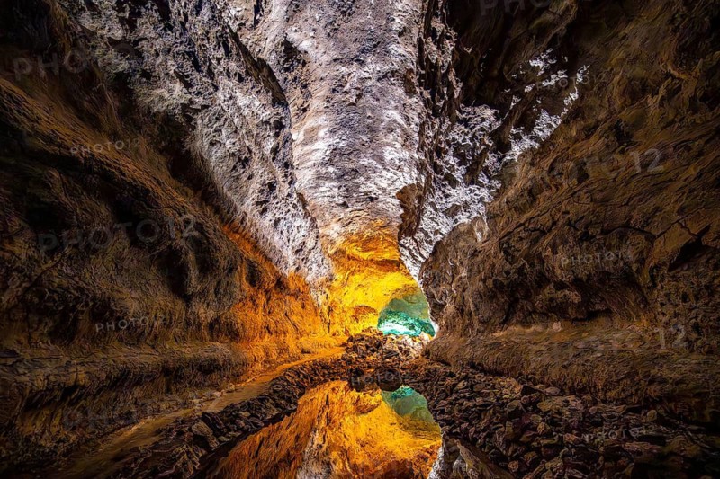 Lava tunnel, illuminated lava cave with perfect reflection in an underground lake, Cueva de los Verdes, Lanzarote, Canary Islands, Spain