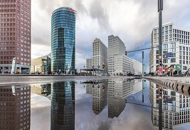 Potsdamer Platz Berlin in the evening with traffic on the streets. When it rains, the skyscrapers are reflected in puddles of water. Bahn-Tower, headquarters of Deutsche Bahn AG. Berlin, Germany