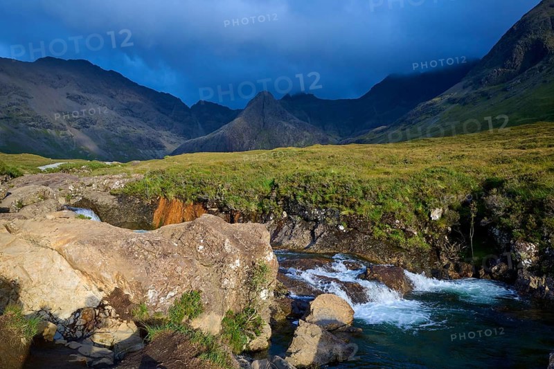 River flowing through a green landscape surrounded by mountains under a cloudy sky, Fairy Pools, Grula, Isle of Skye, Scotland, United Kingdom, Great Britain