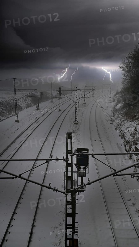Photo montage of snow-covered train tracks under a dramatic thunderstorm sky with lightning, where is Deutsche Bahn going
