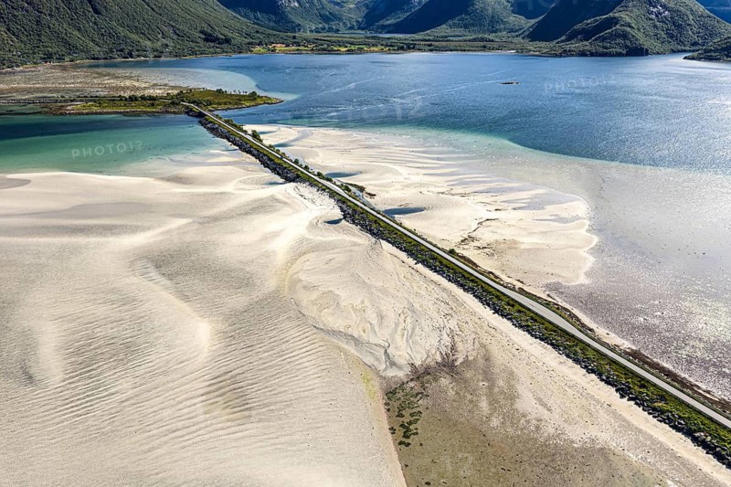Aerial view of a bridge over turquoise sea at a sandy beach, fjord Grunnforfjorden, Lofoten islands, Norway