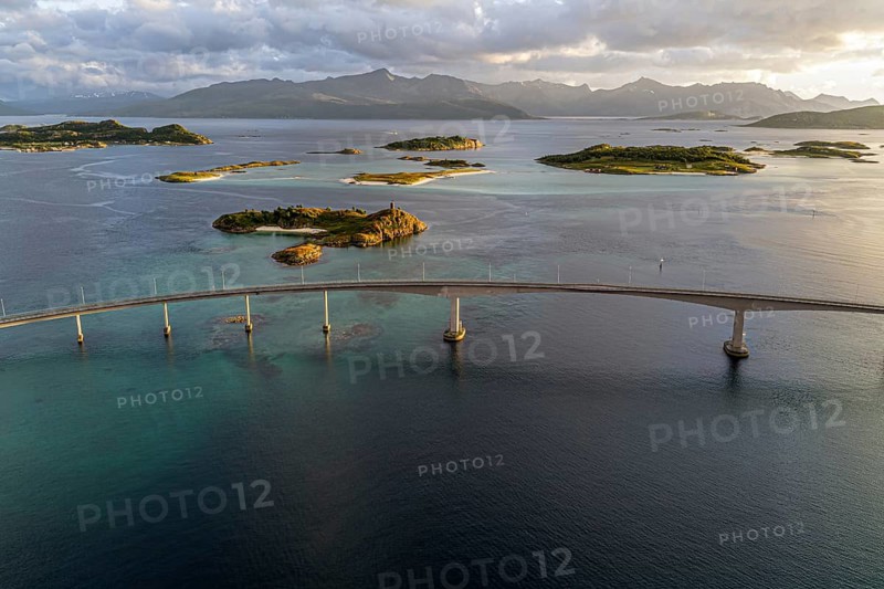 Sommaroy Bridge connecting Kvaloya Island to Sommaroy Island, warm light at sunset, aerial view, Norway