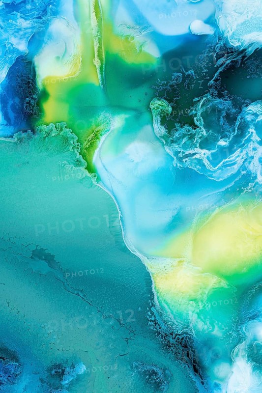 Mesmerizing flow of liquid abstract inks in vibrant blue, green, and yellow colors, creating an organic and ethereal aesthetic ideal for artistic backgrounds