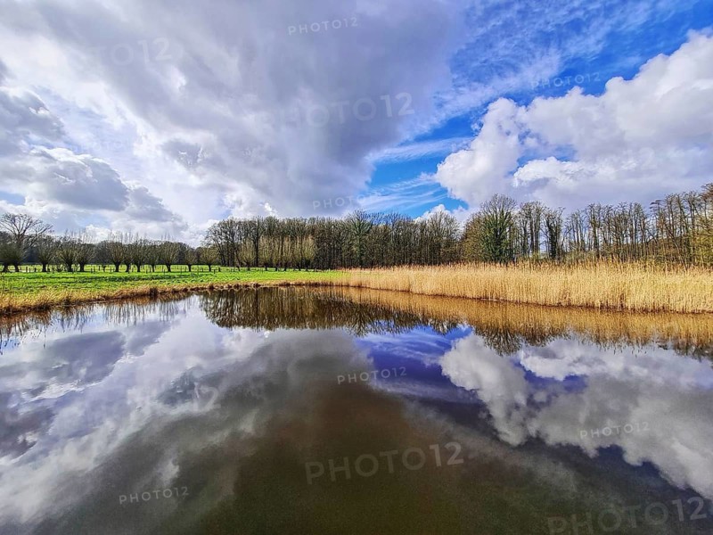 View of small rain with dramatic cloud reflections and horizon line, Nettetal North Rhine-Westphalia Lower Rhine