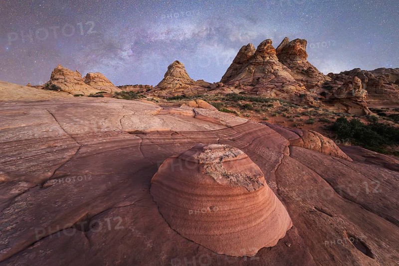 Breathtaking desert landscape showcasing layered rock formations beneath a star filled night sky, capturing the tranquil beauty of nature rugged terrain in Coyote Buttes, Arizona