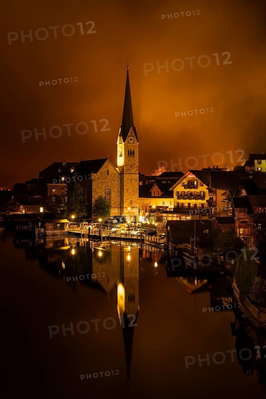 View of Hallstatt with the church and Lake Hallstatt at night. Clouds move through Hallstatt. Reflection. Hallstatt, Gmunden, Salzkammergut, Upper Austria, Austria