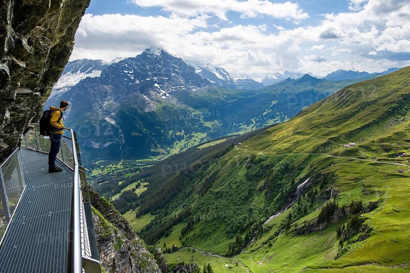 Young man on First Cliff Walk, metal trail on a rocky outcrop, Grindelwald First, in front of impressive mountain scenery, Bernese Alps, Bernese Oberland, Switzerland