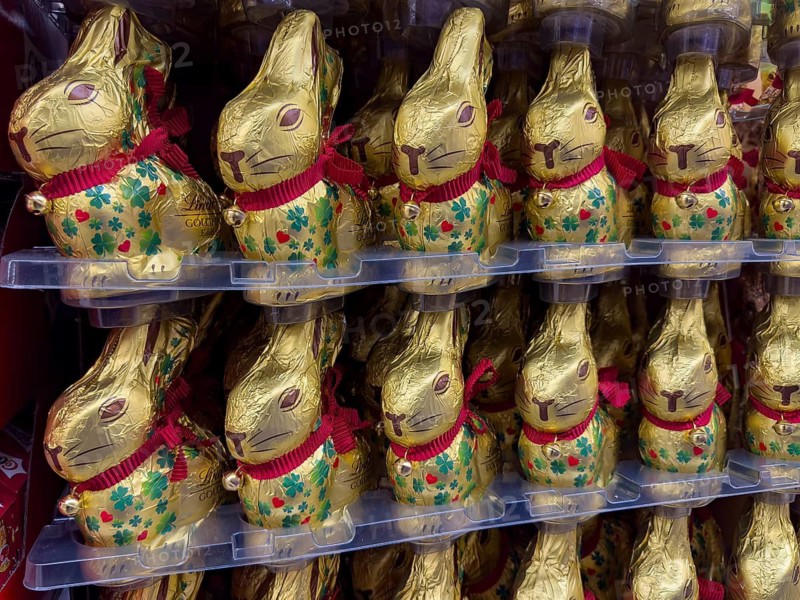 Retail display of chocolate Easter bunnies Easter bunny Easter bunny brand Lindt with chocolate bell wrapped in golden tinfoil paper printed with lucky clover symbol, Germany