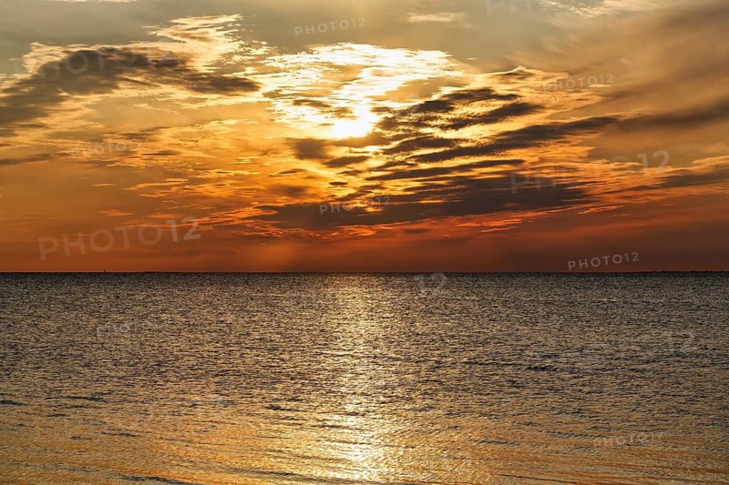 Sunlight glitters golden on the Baltic Sea, evening sky at sunset, Burgsvik, Gotland Island, Sweden