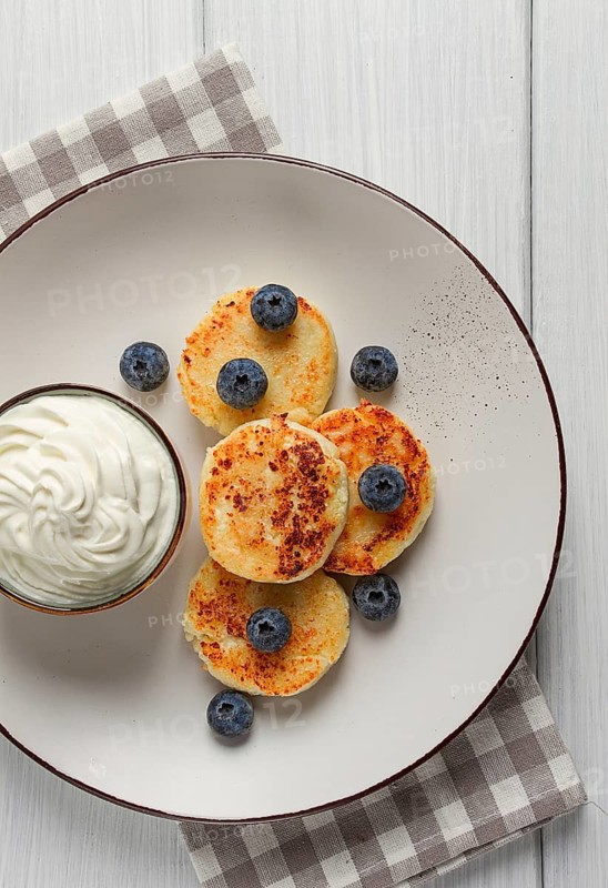 Cottage cheese pancakes, with blueberries, breakfast, on a white wooden table, no people, top view