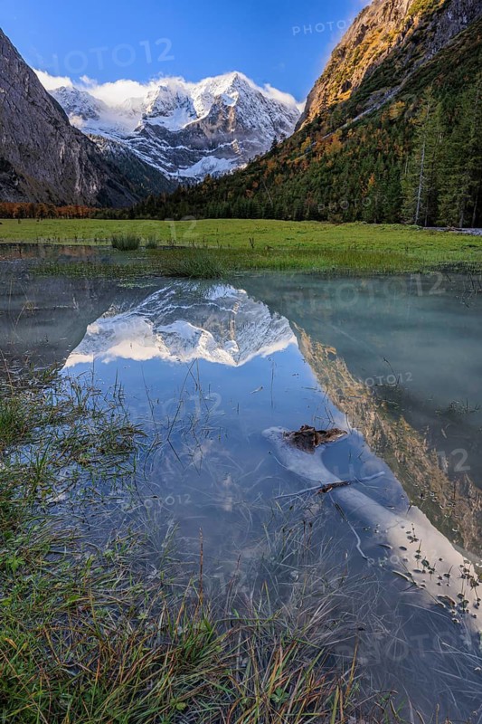 Snow-covered mountains reflected in lake, pond, autumn, Großer Ahornboden, Karwendel Mountains, Tyrol, Austria