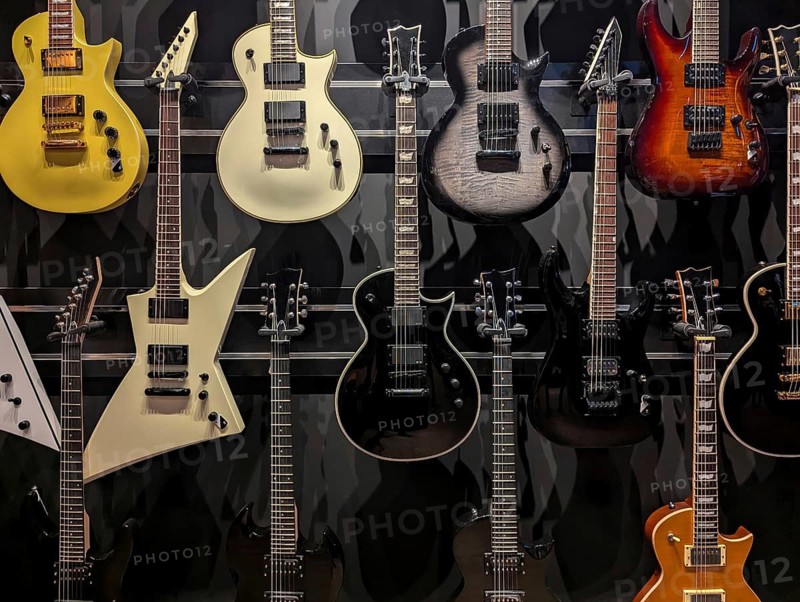 A vibrant selection of electric guitars showcased in a music store. The variety of designs and colors highlights the diversity and style of these musical instruments