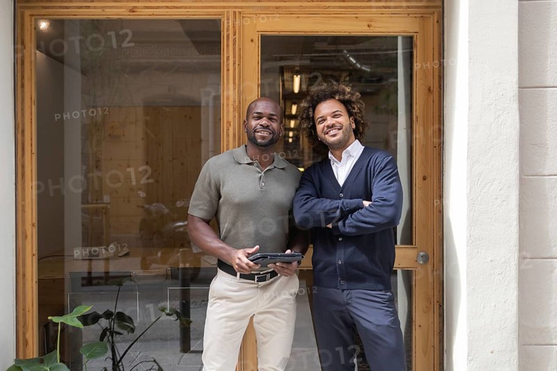 Two professionals stand confidently outside a stylish coworking space in Barcelona, illustrating collaboration and modern work environments in an urban setting