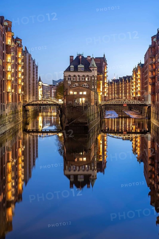 Water castle in Hamburg's Speicherstadt at the blue hour and reflection in the water, Hamburg, Germany