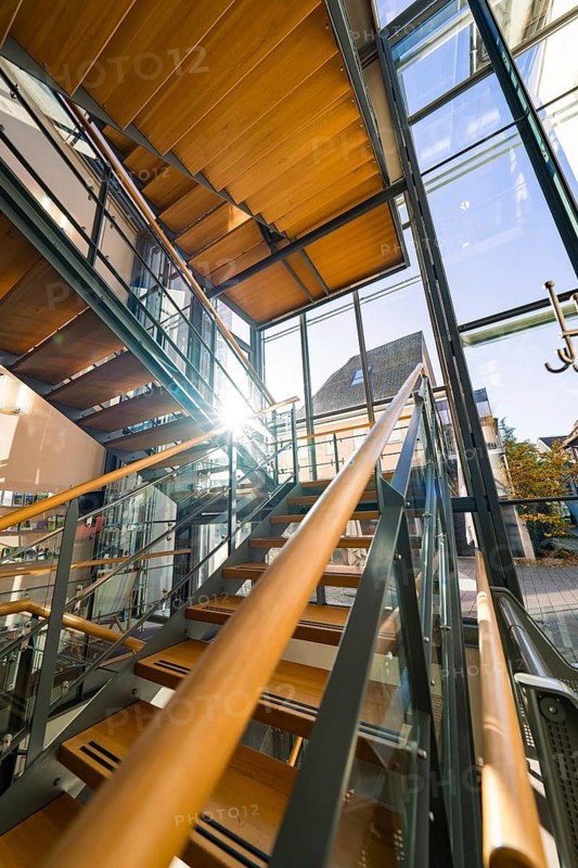 Modern staircase in a building with glass windows and wooden panelling, flooded with sunlight, Nagold Town Hall, Black Forest, Germany