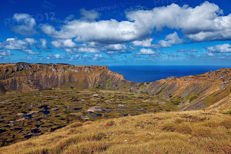 A breathtaking volcanic landscape with crater and ocean views under a blue sky, Ranu Kau volcano on Easter Island in the Pacific Ocean
