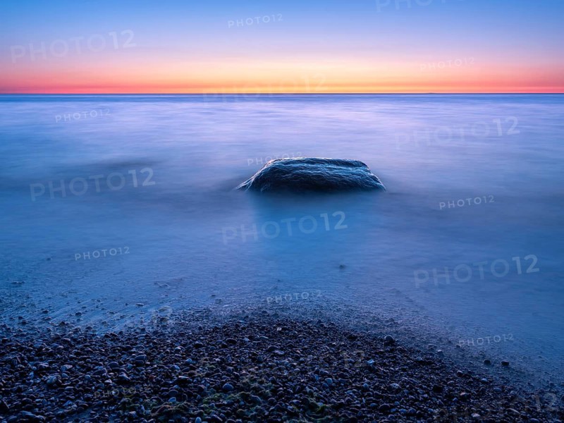 Unspoiled secluded stretch of coast with boulders at sunset on the Baltic Sea beach, near Rerik, Mecklenburg-Western Pomerania, Germany