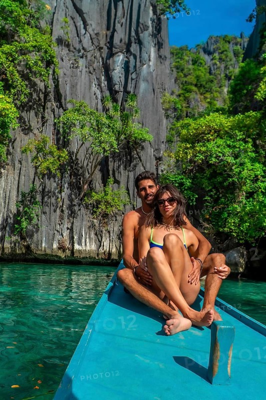 Couple kayaking in turquoise waters of twin lagoon, coron island, embraces the stunning rock formations and lush greenery of the philippines