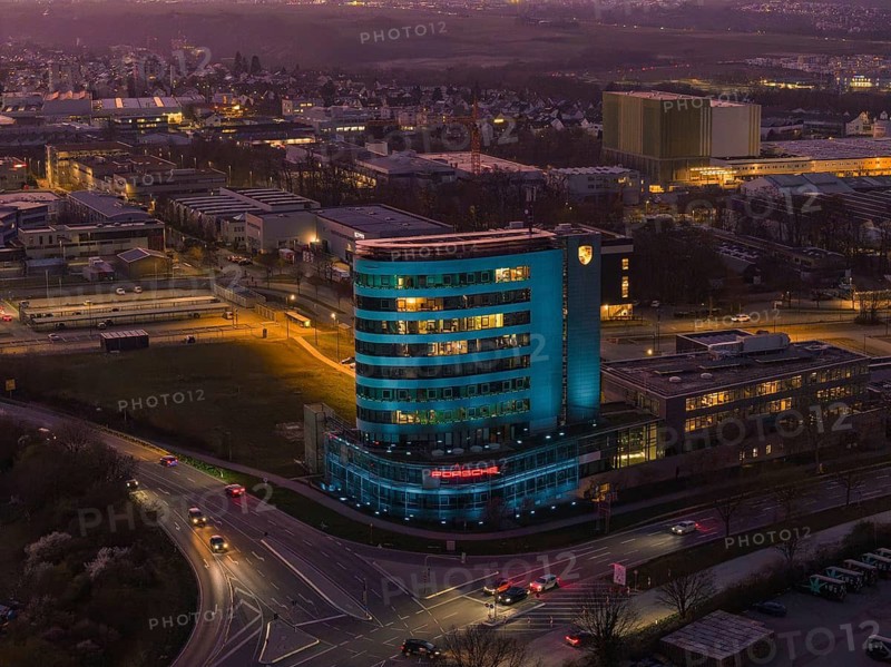 An evening cityscape with an illuminated skyscraper in the center, Porsche, Bietigheim, Germany