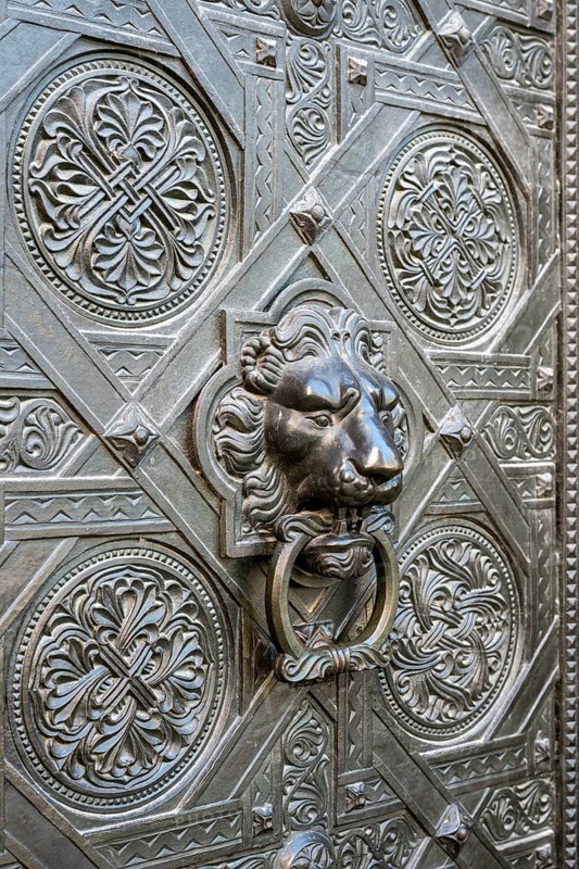 Artfully decorated bronze door with lion's head as a door puller or door knocker on the Gallus portal at the northern transept of Basel Cathedral, Old Town, Basel, Canton of Basel-Stadt, Switzerland
