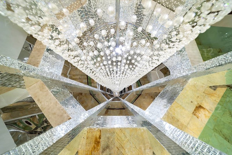 Huge lamp decorated with glass beads in the stairwell, main chedi (Phra That), Buddhist temple complex Wat Phra That Sorn Kaew, Khao Kho mountains, Phetchabun province, Isan, Thailand