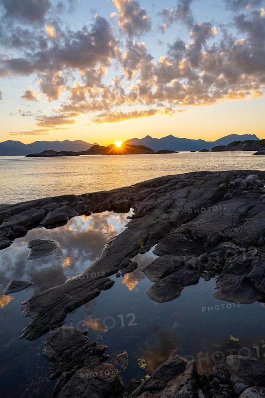 Clouds reflected in a small pond on a rocky coast, coastal landscape at sunset, Henningsvær, Lofoten, Nordland, Norway