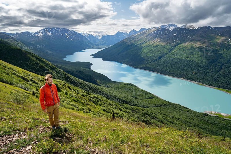 Mountaineer enjoys views of blue lake and mountains on Twin Peaks Trail, Eklutna Lake, Chugach Mountains, Chugach State Park, Alaska, USA