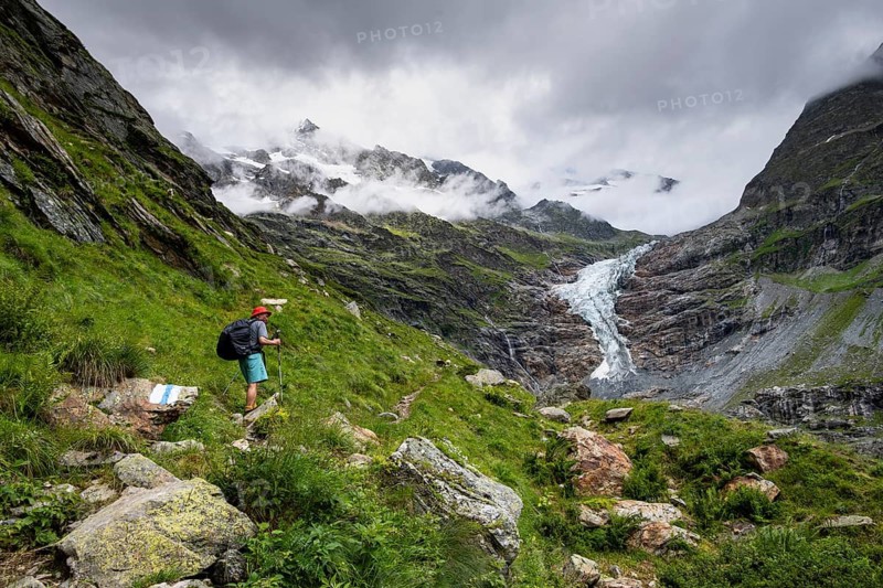 Mountaineers on a hiking trail, cloudy mountain landscape with Lower Arctic Sea glacier, Bernese Alps, Bernese Oberland, Switzerland