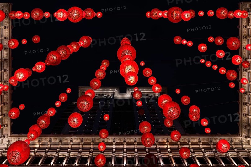 From below a festive red lanterns adorn a classical building in Hong Kong, brilliantly lit against the night sky to celebrate Chinese New Year, showcasing traditional decorations in an urban setting