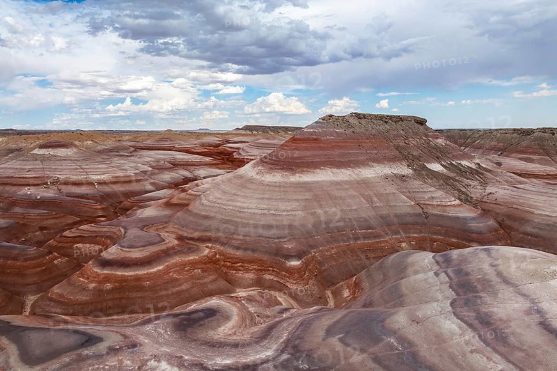 A breathtaking aerial photograph showcasing the unique and textured geological formations near Hanksville, Utah, displaying layered rock formations under a vast sky