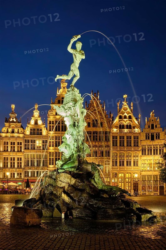 Antwerp famous Brabo statue and fountain on Grote Markt square illuminated at night and old houses. Antwerp, Belgium