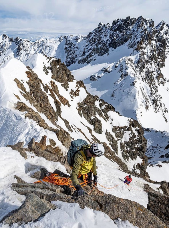 Mountaineer belaying on a steep snow slope, belaying on a rope, ascent to the summit of Piz Grialetsch in winter, view of mountain panorama with snow, Grisons Haute Route, Albula Alps, Rhaetian Alps, Grisons, Switzerland