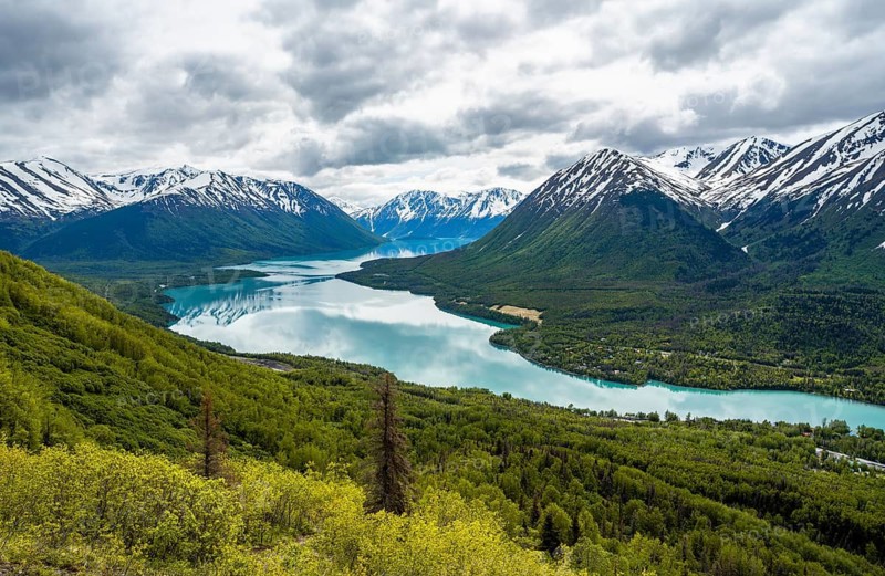 View of snowy mountains in spring and turquoise blue Kenai Lake, Slaughter Ridge Trail, Cooper Landing, Kenai Peninsula, Alaska, USA