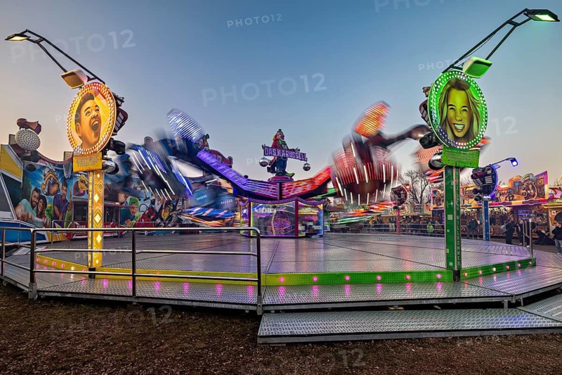 A spinning ride with colorful lights and blurred movements at dusk, carousel and the hustle and bustle of summer profit in Eisenach