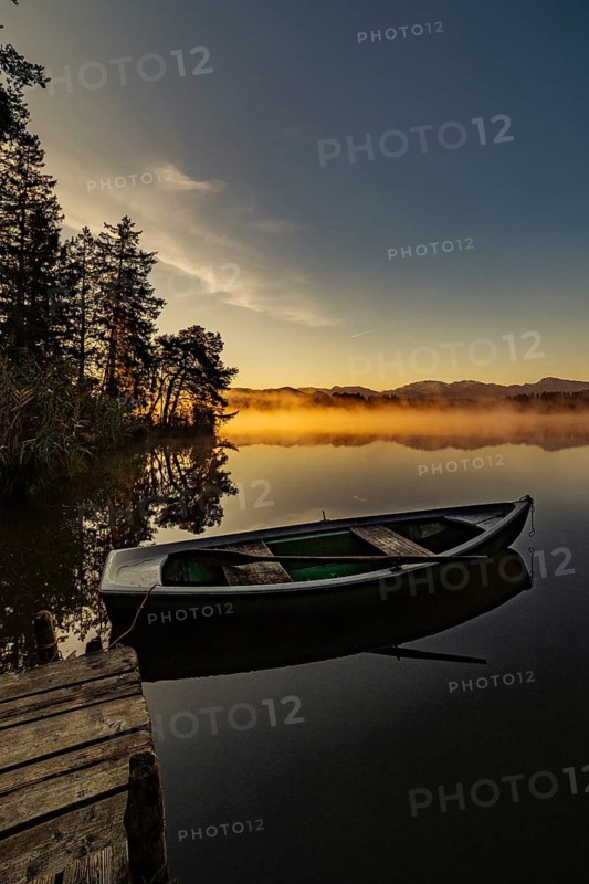 Boats in the autumnal Schmutter Weiher in the Allgäu near the municipalities of Halblech, Roßhaupten and Lechbruck in Ostallgäu in the foothills of the Alps