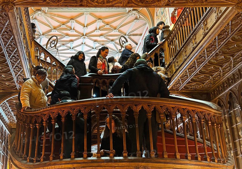 Livraria Lello, interior view of the Lello bookstore with lots of tourists on the curved wooden staircase, Overtourism, Porto, Portugal