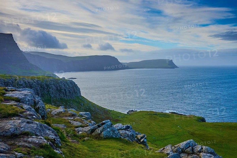 Cliffs by the sea with green areas under a dynamic sky, Waterstein Head, Waterstein, Isle of Skye, Scotland, United Kingdom, Great Britain