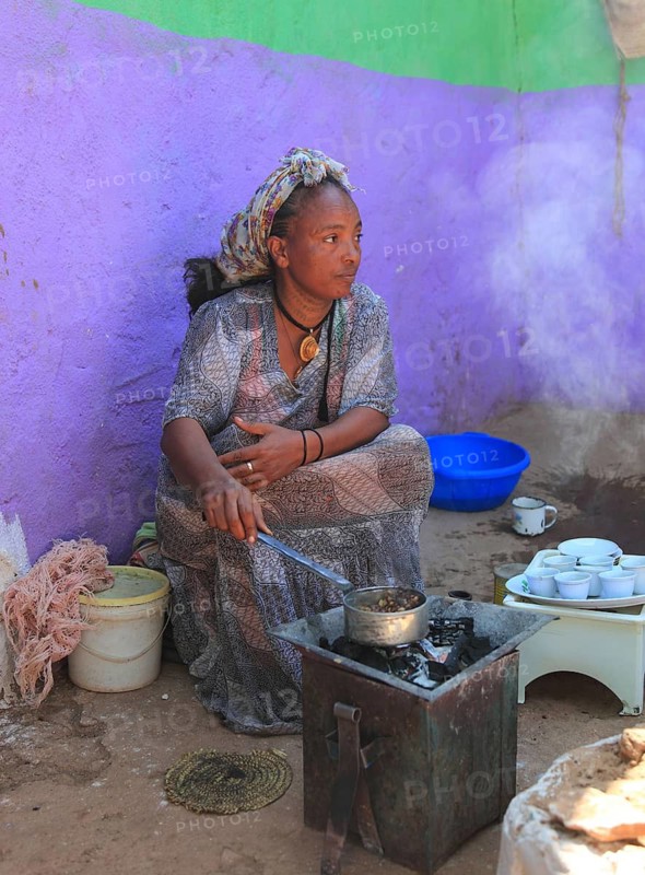 In the highlands of Abyssinia, in the village of Sina, young woman roasting coffee for the coffee ceremony, Ethiopia