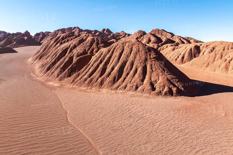 Scenic view of the Devil's Desert in Salta, Argentina, showcasing striking red rock formations under a clear blue sky, illustrating the region's unique desert landscape