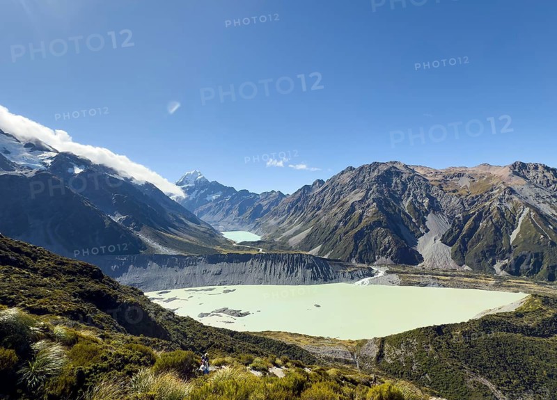 A breathtaking view of Mount Cook during autumn, showcasing its majestic peaks and serene glacial waters under a clear blue sky, reflecting the natural beauty of New Zealand landscape