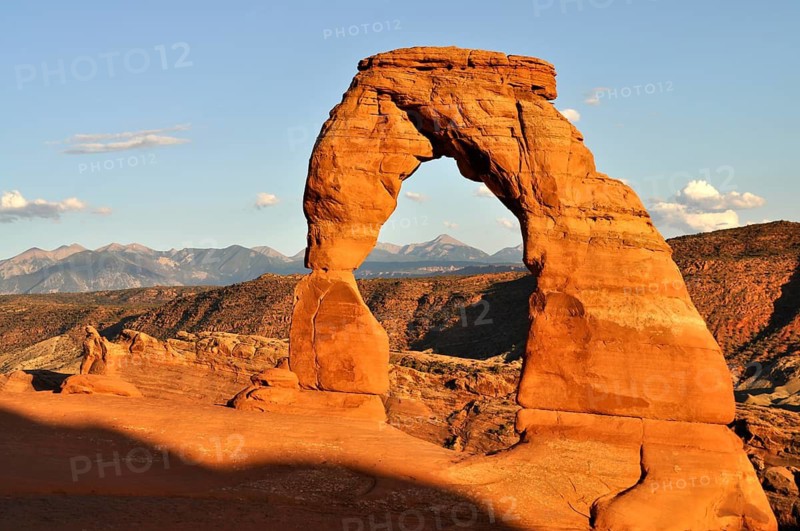 The Delicate Arch when the sun is low with mountains in the background, Arches National Park, Utah, USA