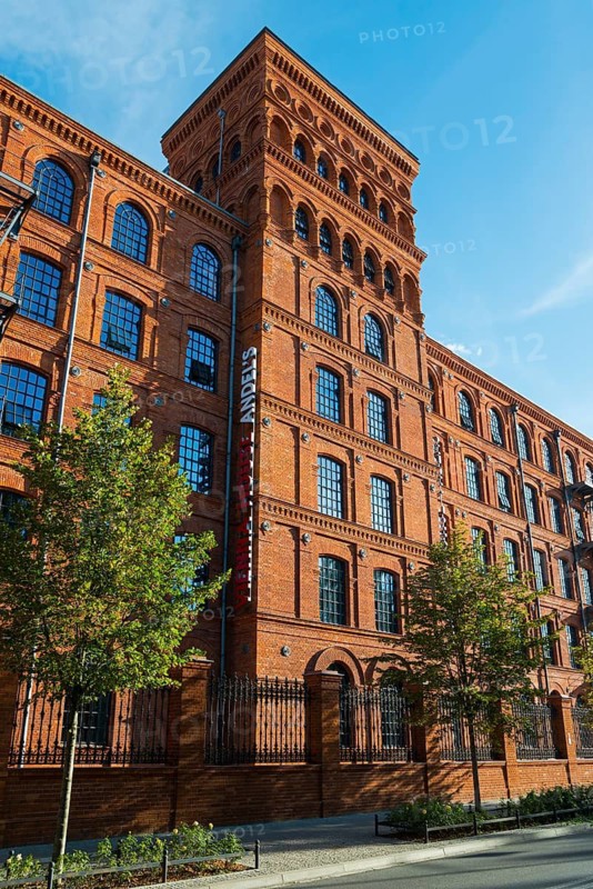 Tall brick building in sunlight, surrounded by trees and blue sky, Manufaktura, Lódz, Lodz, Lodz, Poland