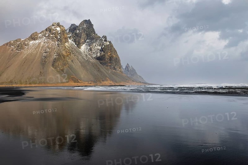 Sea waves on lava sandy beach against mountain backdrop, sleet showers, winter, Stokksnes, Vestrahorn, Klifatindur, Höfn, Iceland, Scandinavia