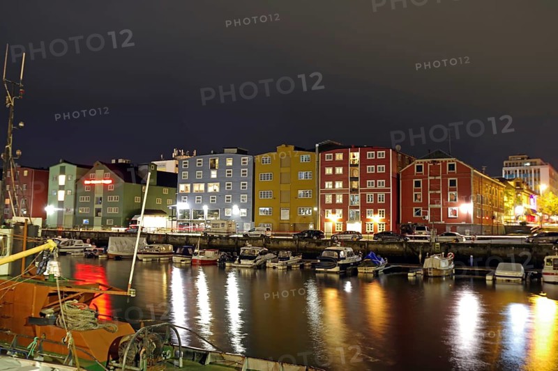 Colourful, illuminated buildings and boats on a quiet, reflected harbor at night, Nidelva, Trondheim, Tröndelang, Norway