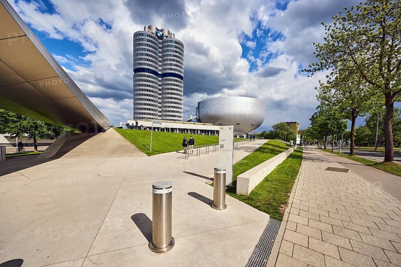 BMW museum, car museum, BMW corporate headquarters, high-rise building, modern architecture, commercial building, architect Karl Schwanzer, BMW four-cylinder, BMW tower, BMW high-rise building, barrier bollard, sidewalk, roadway, meadow, trees, blue sky, white and dark gray cumulus clouds, Lerchenauer Straße, Munich, state capital, district-free city, Bavaria, Germany